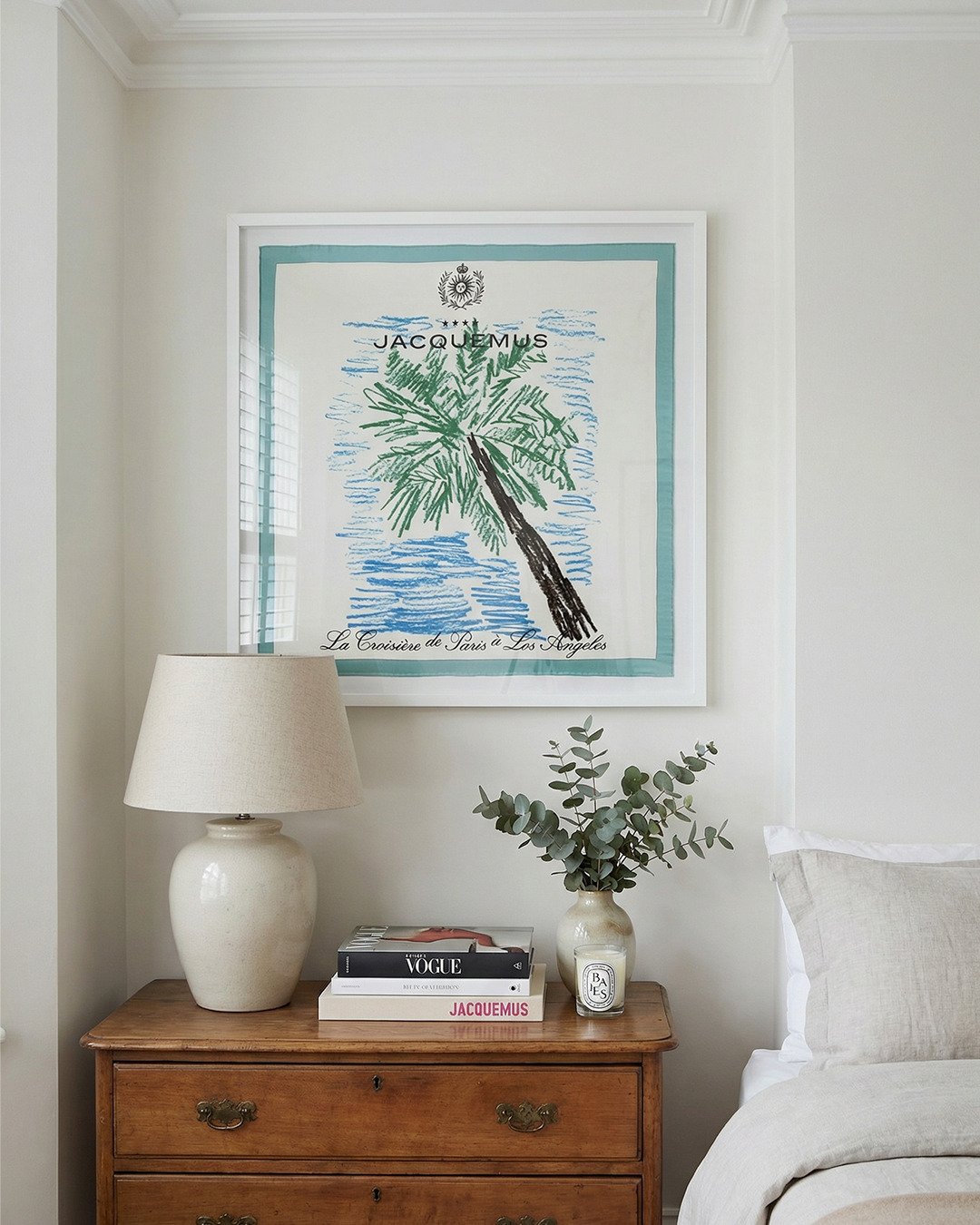 A framed silk scarf of a hand drawn palm tree design from Jacquemus. The artwork hangs in a London bedroom.